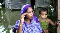 Woman holding child in flooded area