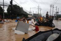 People waist-deep and on rafts in floodwater on street