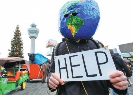 Man with earth on his head holding a sign that says Help
